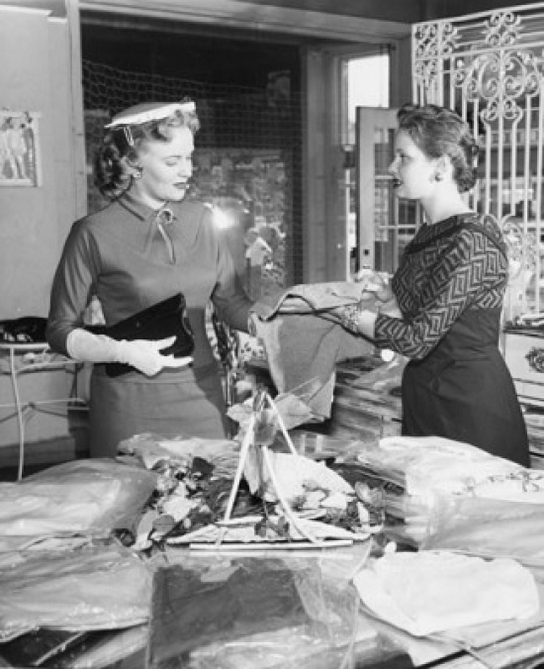 Side profile of female sales clerk showing clothes to customer Canvas Art - (24 x 36)