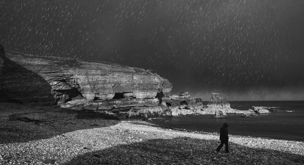 Silhouette of a man walking towards the water under a starry sky at night South Shields Tyne and Wear England Canvas Art - John Short  Design Pics (42 x 22)