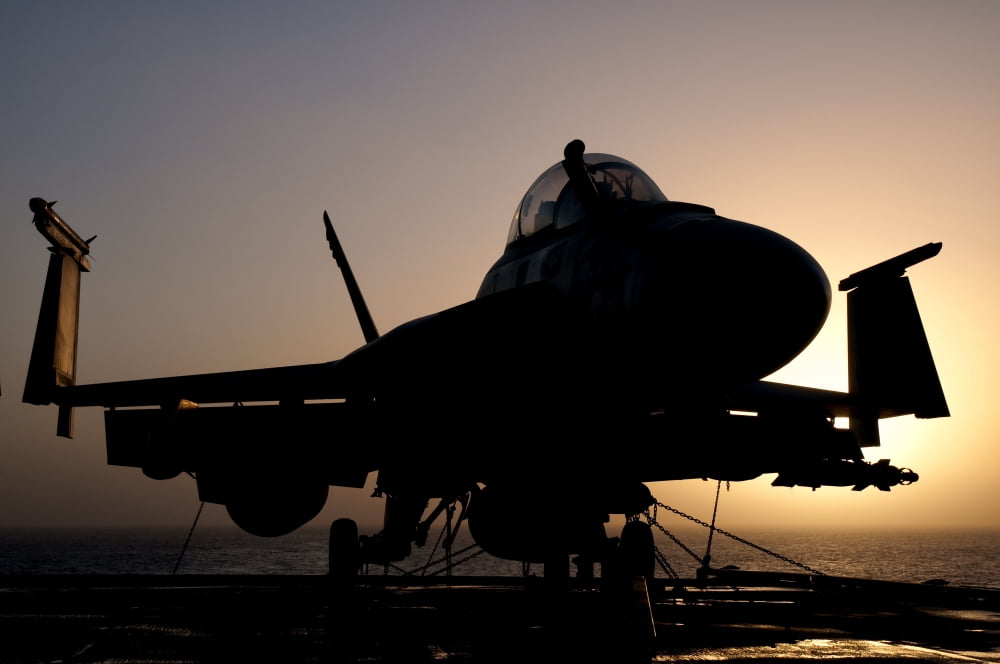 Silhouette of a US Navy FA-18E Super Hornet on the flight deck of USS Nimitz Canvas Art - Giovanni CollaStocktrek Images (18 x 12)