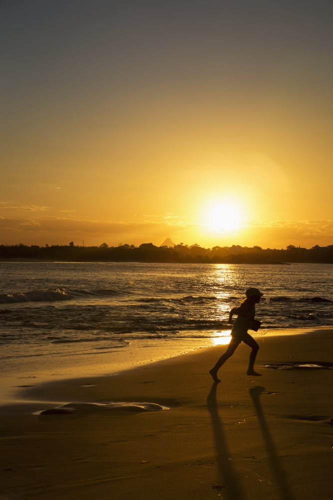Silhouette of a child running on a beach at sunset Caloundra Queensland Australia Canvas Art - John Short Design Pics (24 x 38)