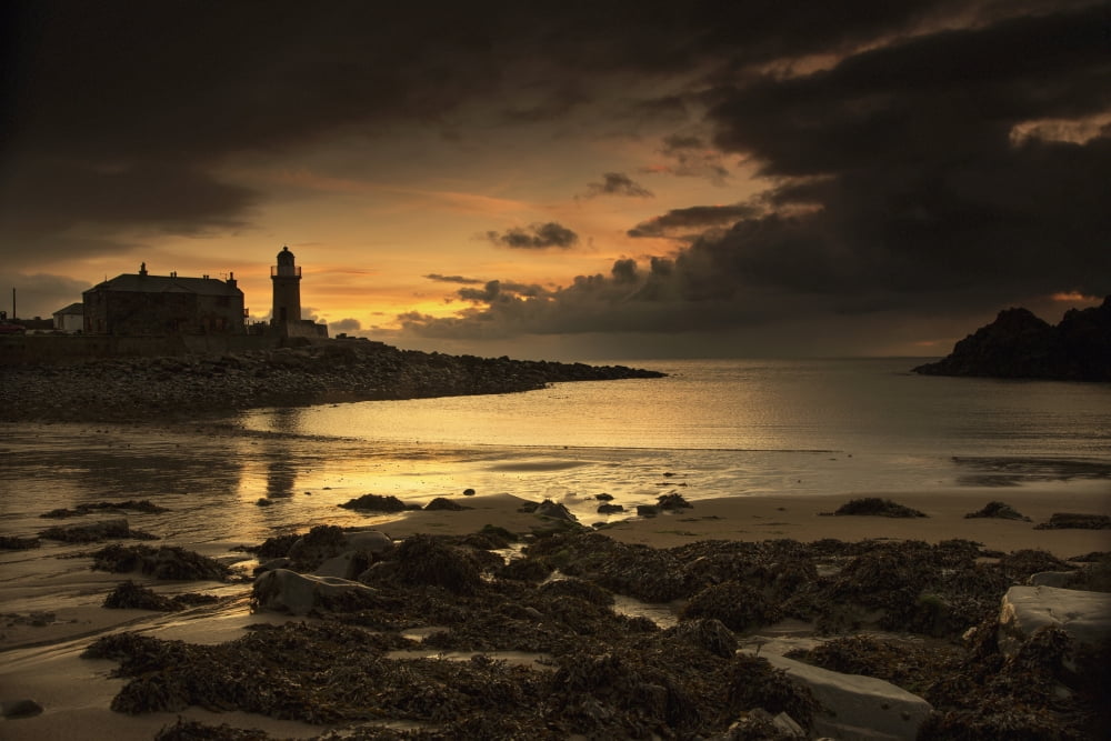 Silhouette of a lighthouse along the coast at sunsetPortpatrick dumfries and galloway scotland Canvas Art - John Short Design Pics (19 x 12)