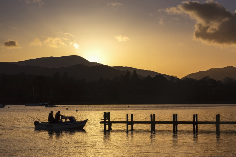 Silhouette of fishermen in a boat arriving at a dock on a lake at sunset Keswick Cumbria England Canvas Art - John Short Design Pics (38 x 24)