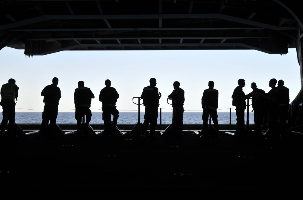 Silhouette of sailors standing in the hangar bay aboard USS Carl Vinson Canvas Art - Stocktrek Images (35 x 23)