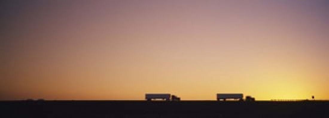 Silhouette of two trucks moving on a highway Interstate 5 California USA Canvas Art - Panoramic Images (18 x 7)