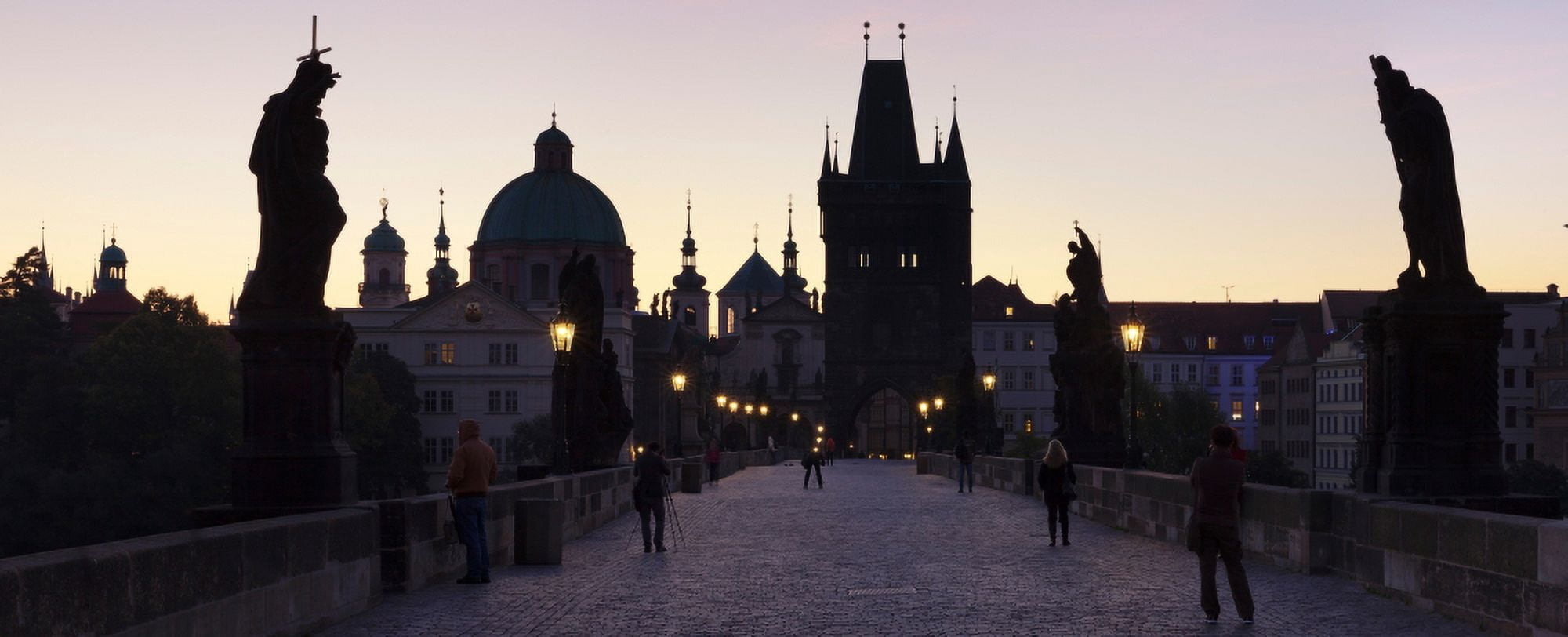 Silhouette of statues on Charles Bridge with St Francis Church and Old Town Bridge Tower in the background Prague Czech Republic Canvas Art - Panoramic Images (27 x 9)
