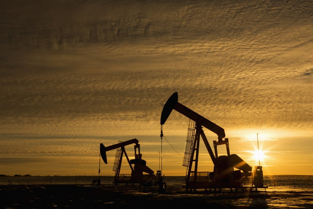 Silhouette of two pump jacks at sunrise with sun burst and colourful clouds in the sky Alberta Canada Canvas Art - Michael Interisano Design Pics (38 x 24)