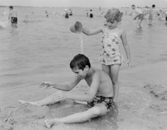Sister pouring water from bucket at his brother on beach Canvas Art - (18 x 24)