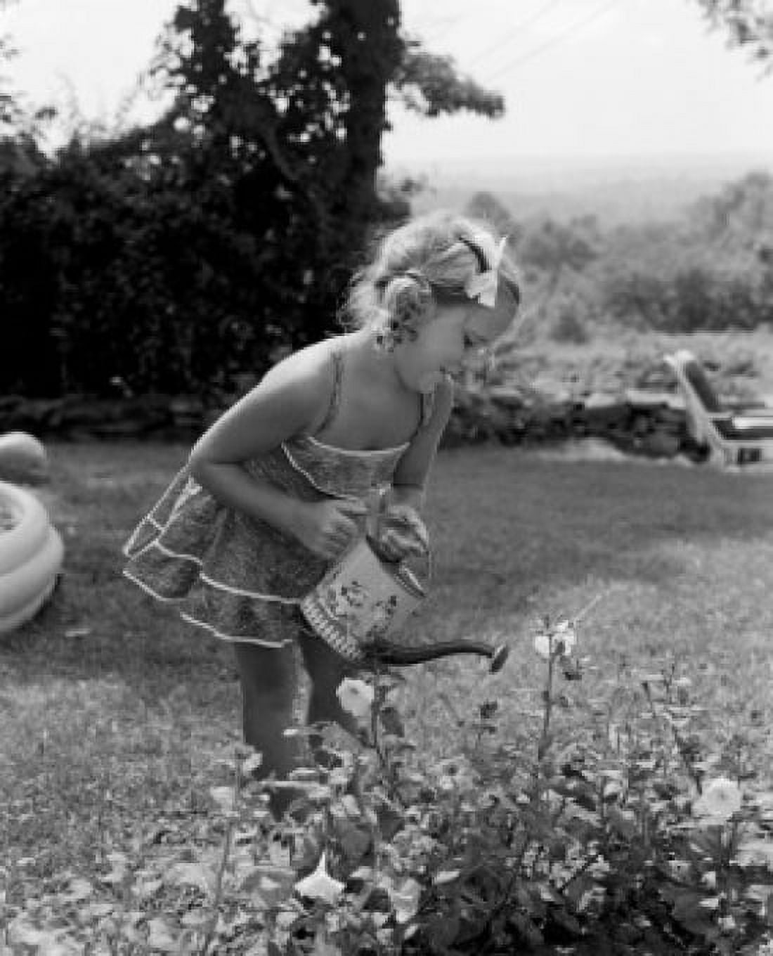 Small girl watering flower in garden Canvas Art -  (18 x 24)