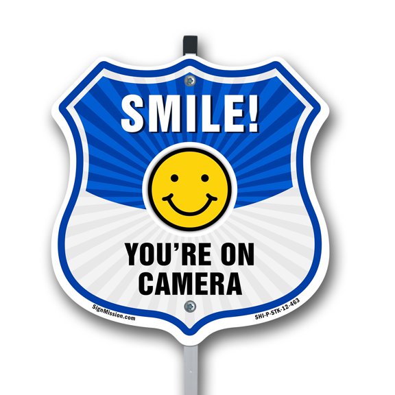 Smile You're On Camera Shield Sign Smile You're On Camera 12 inch X 12 inch Shield Shaped Commercial Grade Plastic Sign with Aluminum Mounting Stake Weather Resistant, UV Protected for