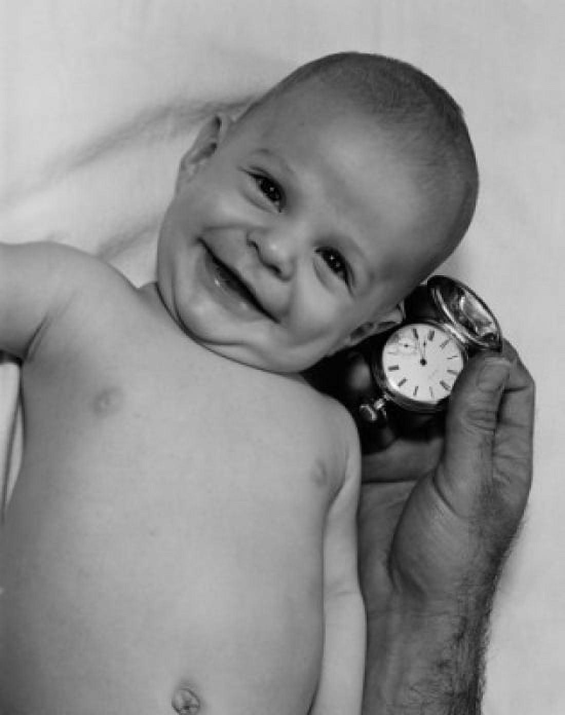 Smiling baby and hand of adult man holding watch Canvas Art - (18 x 24)