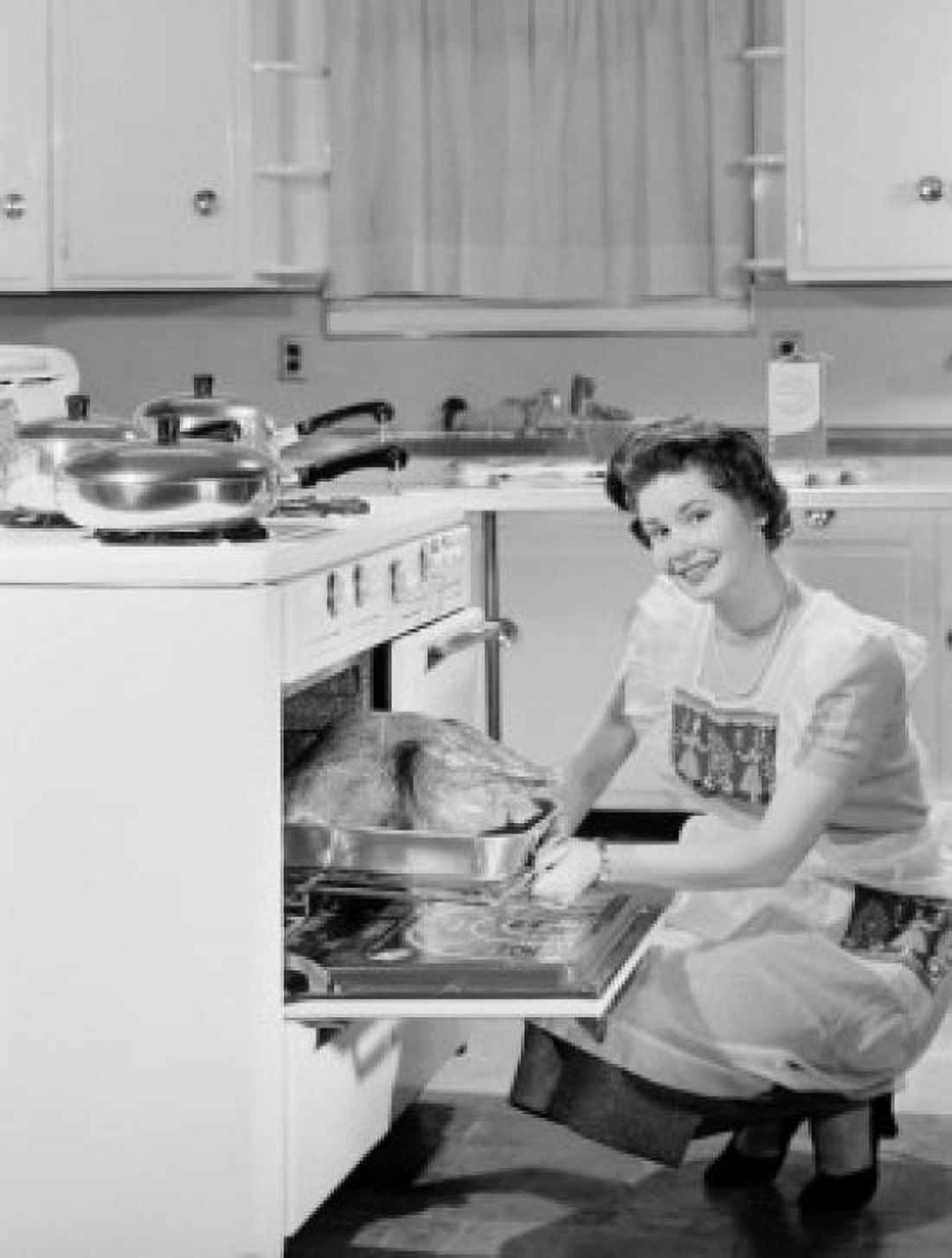 Smiling housewife taking out roasted turkey from cooker and smiling Canvas Art - (18 x 24)
