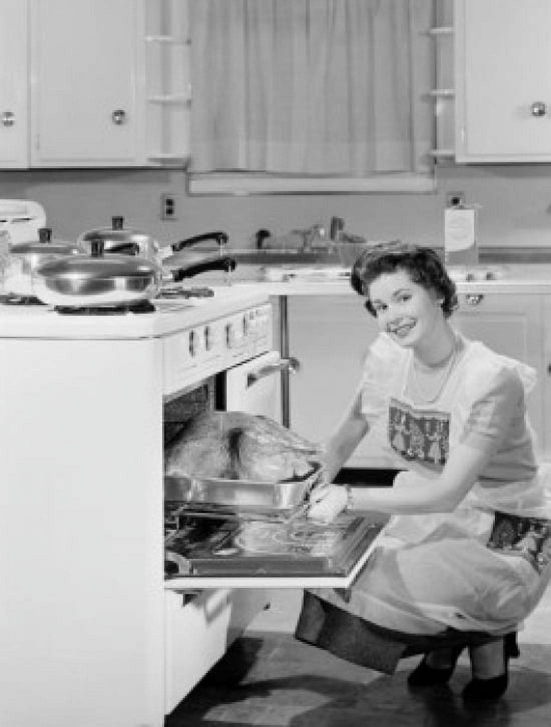 Smiling housewife taking out roasted turkey from cooker and smiling Canvas Art - (24 x 36)