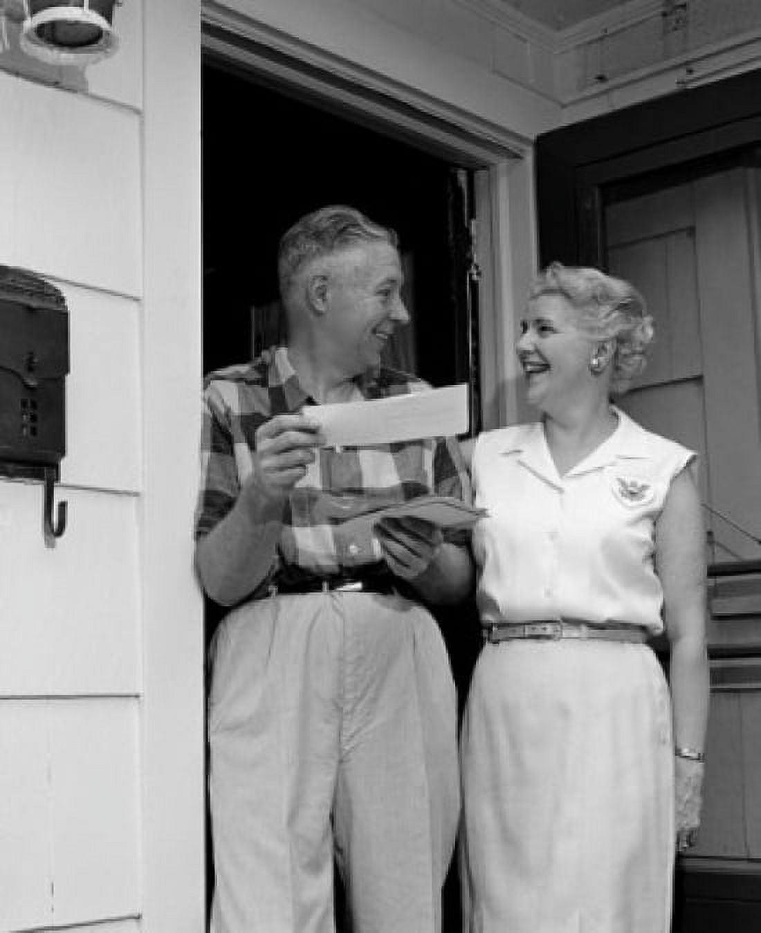 Smiling senior couple standing at front door holding letters Canvas Art - (24 x 36)