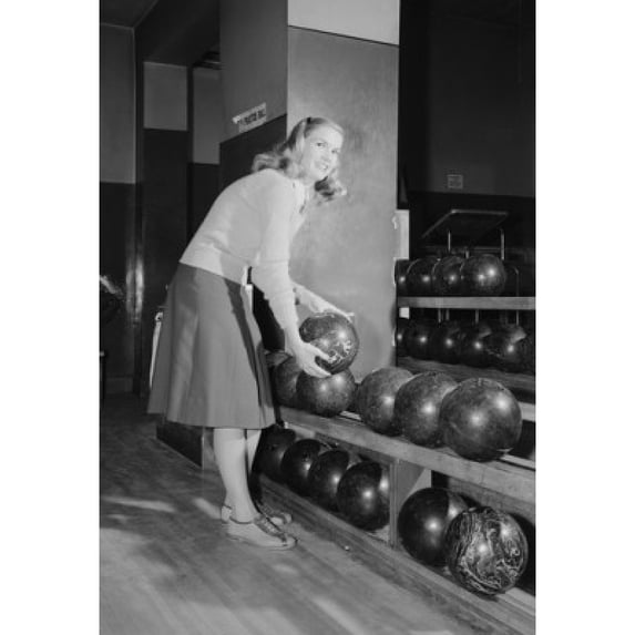 Smiling young woman holding bowling ball Poster Print (18 x 24)