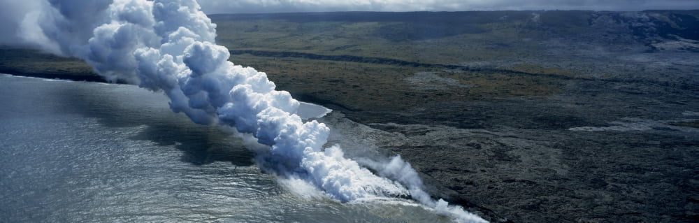 Smoke erupting from volcano at coast Hawaii Volcanoes National Park Hawaii USA Canvas Art - Panoramic Images (12 x 36)
