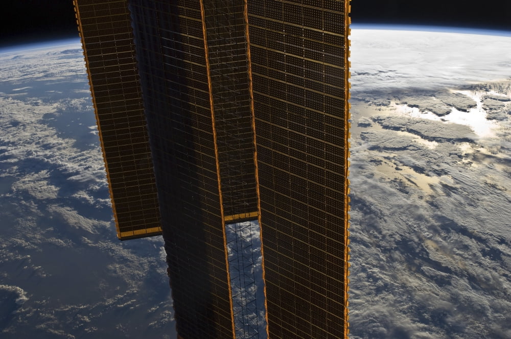 Solar panels of the International Space Station backdropped by a blue and white Earth Canvas Art - Stocktrek Images (34 x 23)
