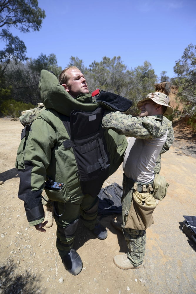 Soldier provides assistance in putting on a bomb suit Canvas Art - Stocktrek Images (23 x 35)