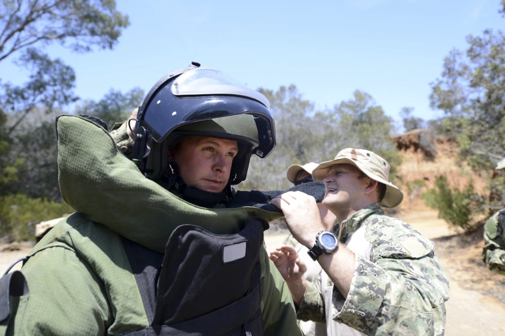 Soldier provides assistance in putting on a bomb suit Canvas Art - Stocktrek Images (35 x 23)