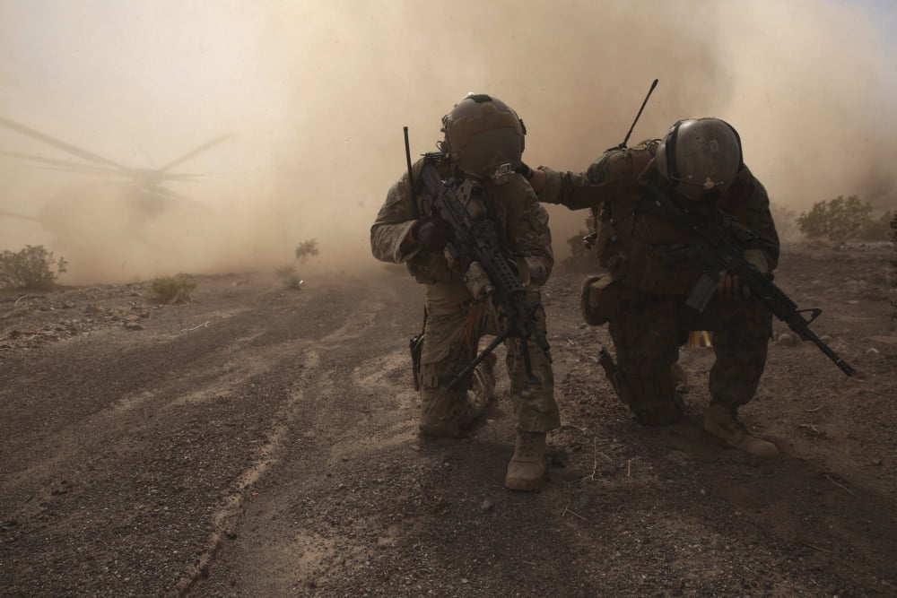 Soldiers brace for the impact of a cloud of sand and rocks from a landing CH-53 Super Stallion Canvas Art - Stocktrek Images (34 x 23)
