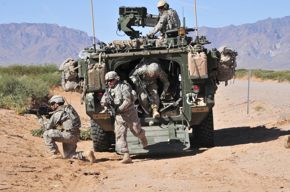 Soldiers dismount from a Stryker vehicle Canvas Art - Stocktrek Images (35 x 23)