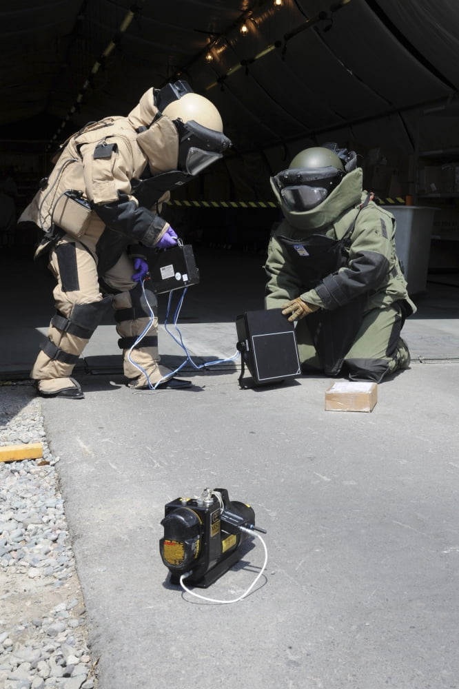Soldiers dressed in bomb suits examine a suspicious package Canvas Art - Stocktrek Images (24 x 35)