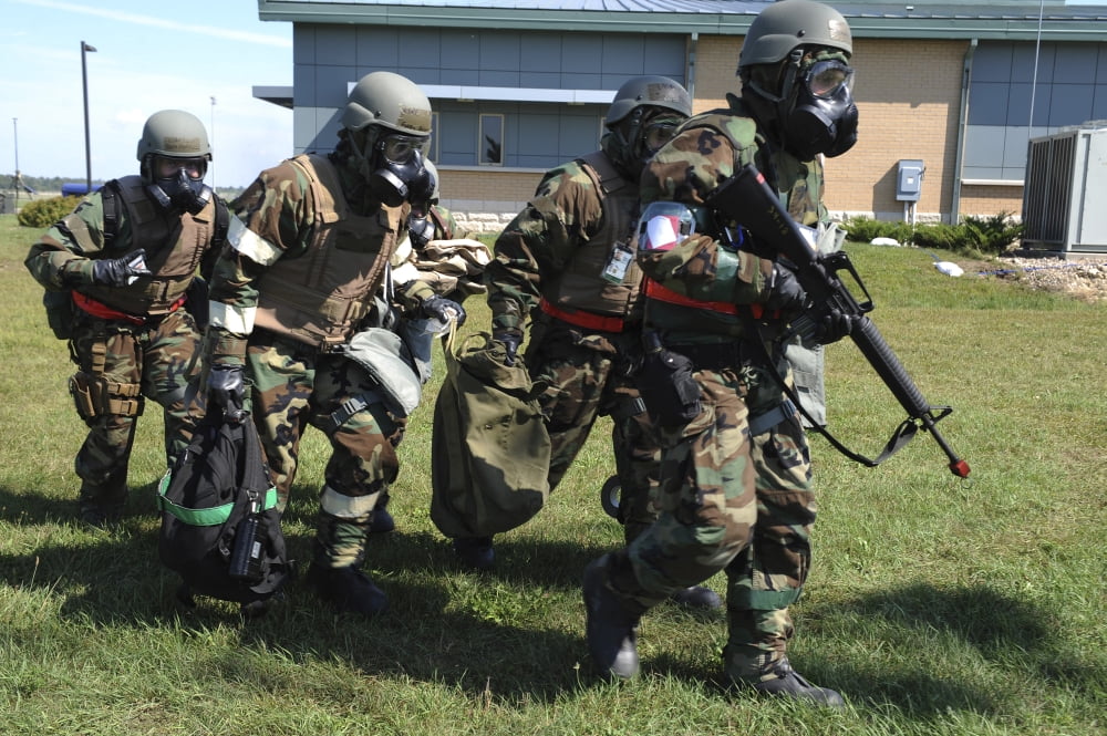 Soldiers dressed in chemical warfare gear carry equipment Canvas Art - Stocktrek Images (35 x 24)