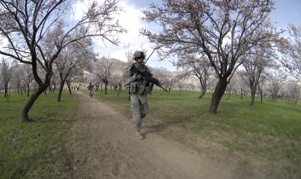 Soldiers walk through an almond orchid while on a dismounted patrol mission Canvas Art - Stocktrek Images (37 x 22)