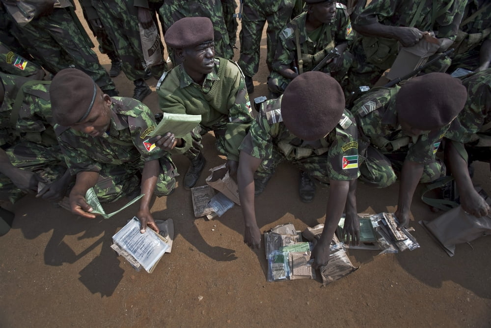 Soldiers with the Armed Forces for the Defense of Mozambique examine Meals Ready to Eat Canvas Art - Stocktrek Images (34 x 23)
