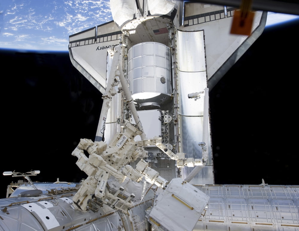 Space shuttle Discovery and the Canadian-built Dextre docked to the International Space Station Canvas Art - Stocktrek Images (32 x 25)