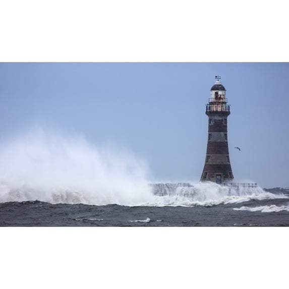Splashing water from a crashing wave against a lighthouse;Sunderland Tyne and Wear England Poster Print