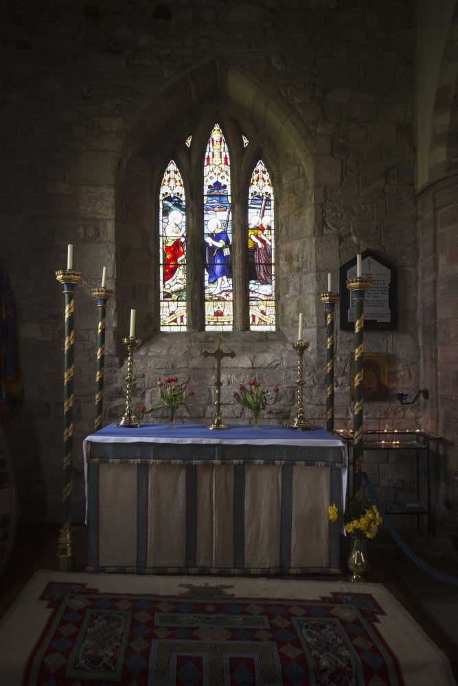 Stained glass windows and a table surrounded with candles in a church Bamburgh Northumberland England Canvas Art - John Short Design Pics (12 x 19)