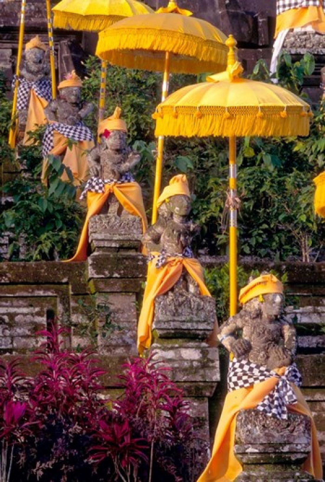 Statues at Mother Temple Adorned in Yellow Indonesia Canvas Art - John & Lisa Merrill DanitaDelimont (18 x 26)