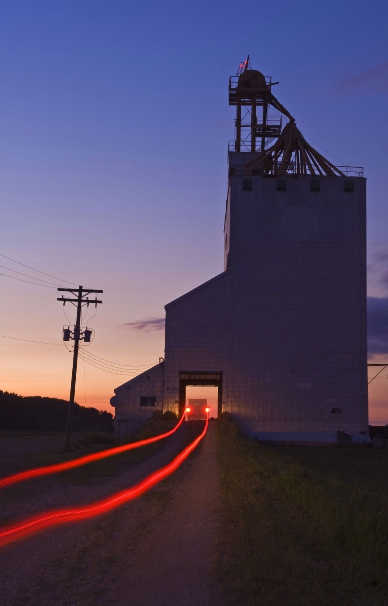 Streak Of Truck Lights And An Old Grain Elevator Virden Manitoba Canvas Art - Dave Reede Design Pics (22 x 36)