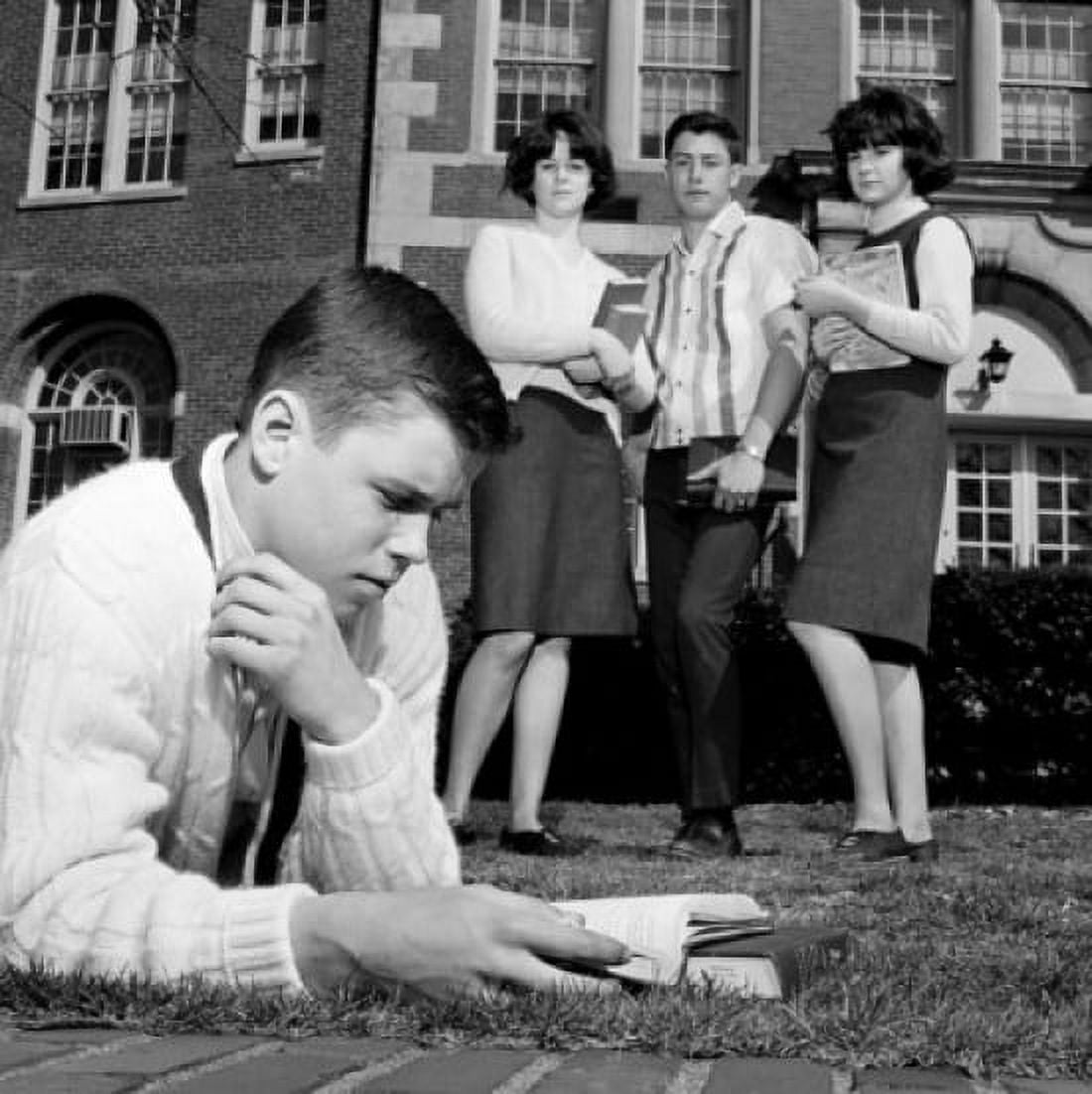 Students watching friend reading on grass outside university Canvas Art - (24 x 36)