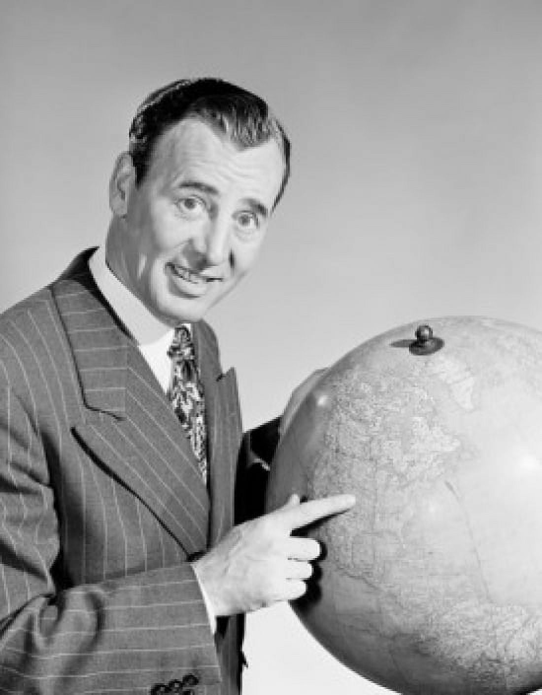 Studio portrait of businessman pointing at globe Canvas Art - (24 x 36)