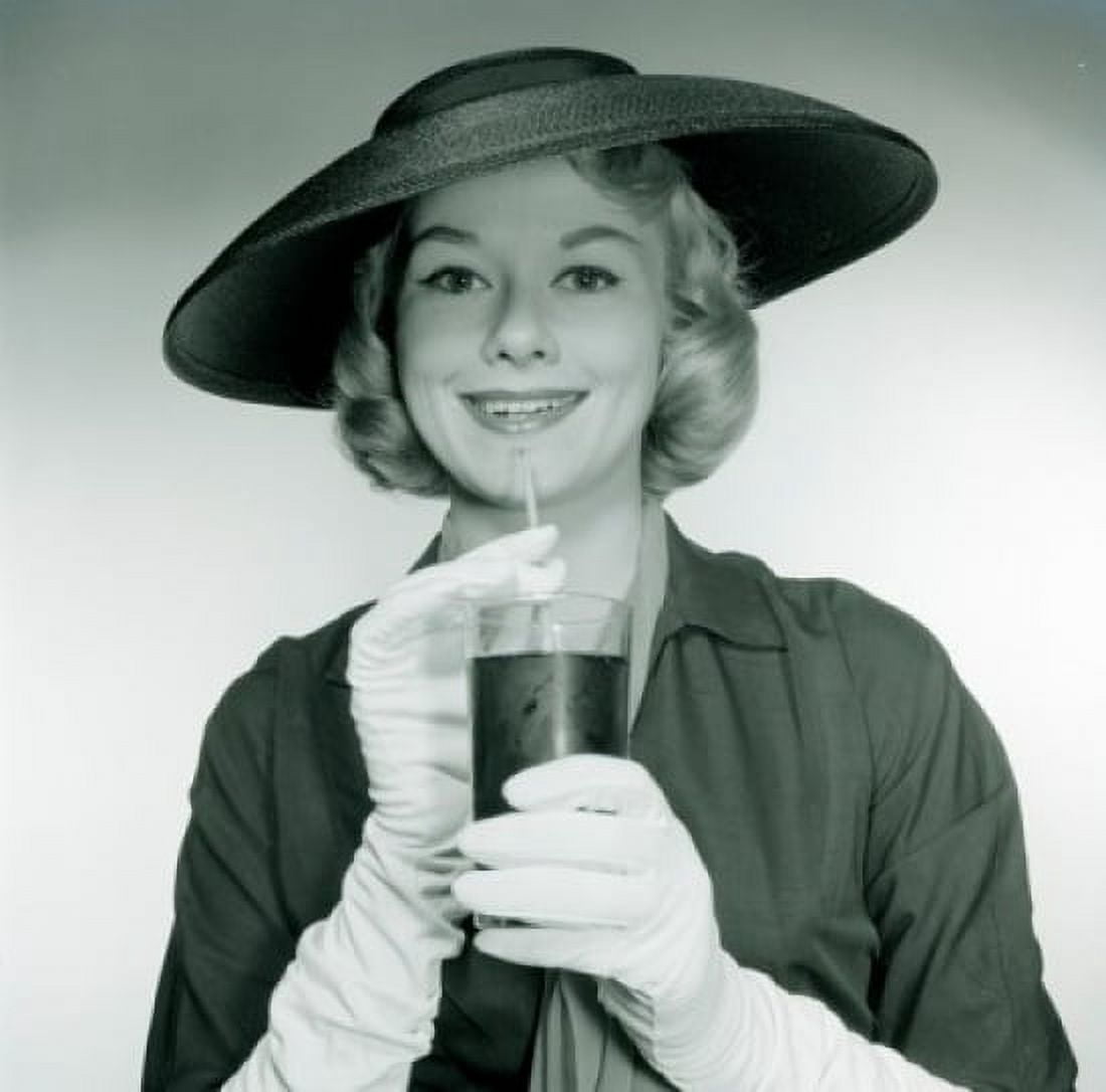 Studio portrait of smiling young woman wearing hat and gloves holding glass Canvas Art - (24 x 36)