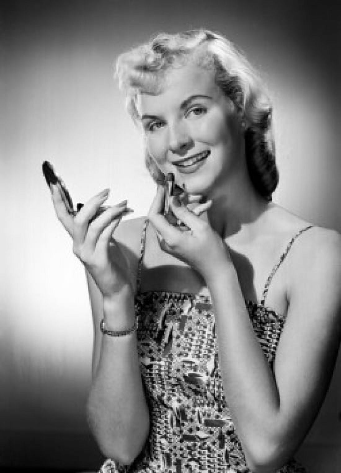 Studio portrait of young woman applying lipstick Canvas Art - (24 x 36)