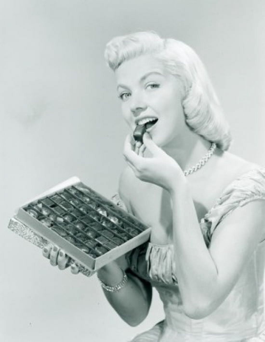 Studio portrait of young woman eating chocolates from box Canvas Art - (24 x 36)