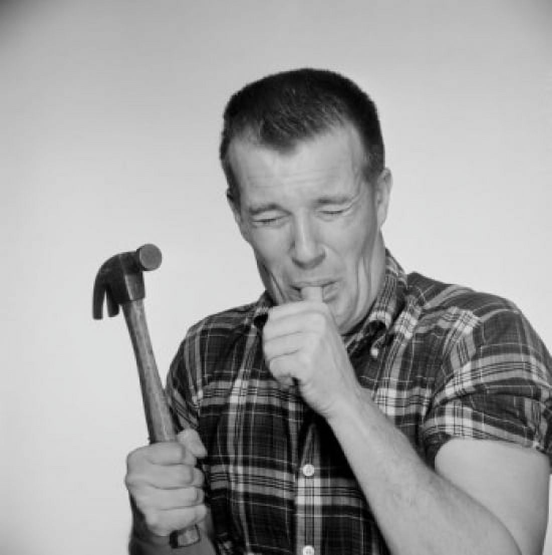 Studio shot of mature man holding hammer and licking finger Canvas Art - (18 x 24)