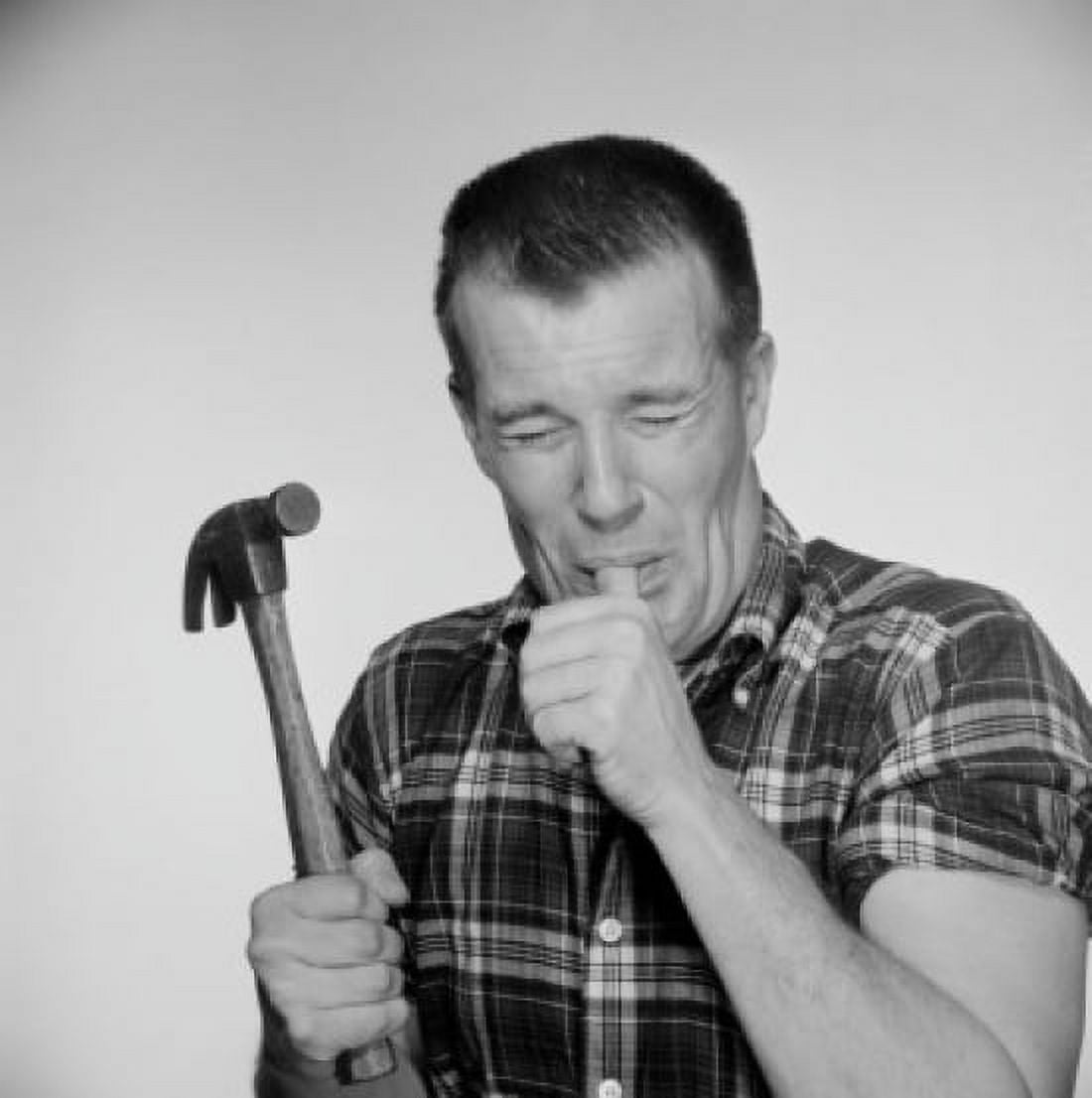 Studio shot of mature man holding hammer and licking finger Canvas Art - (24 x 36)