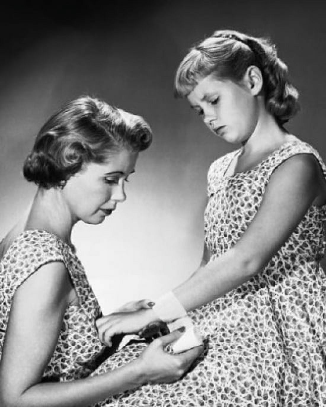 Studio shot of mother applying bandage around daughters wrist Canvas Art - (18 x 24)
