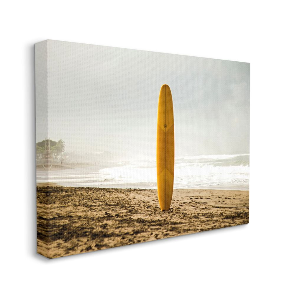 Stupell Industries Yellow Surfboard in Sand Near Shore Photograph Designed by Unsplash