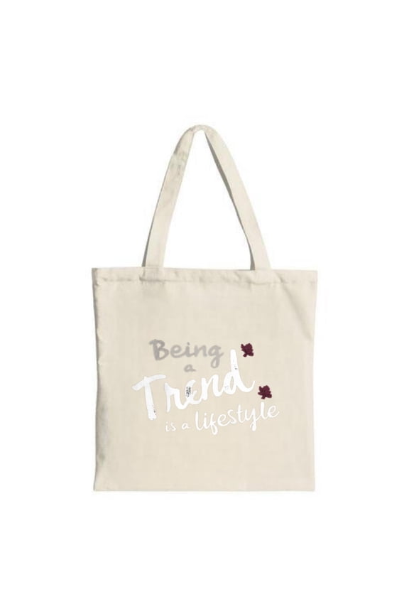 Stylish Canvas Tote Bag with " Being a Trend is a Lifestyle " in white gray adorned with maroon flowers on a light background