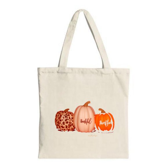 Stylish canvas tote bag featuring three whimsical pumpkins labeled ' indefat funkful ' and ' indefat ' on a light beige background