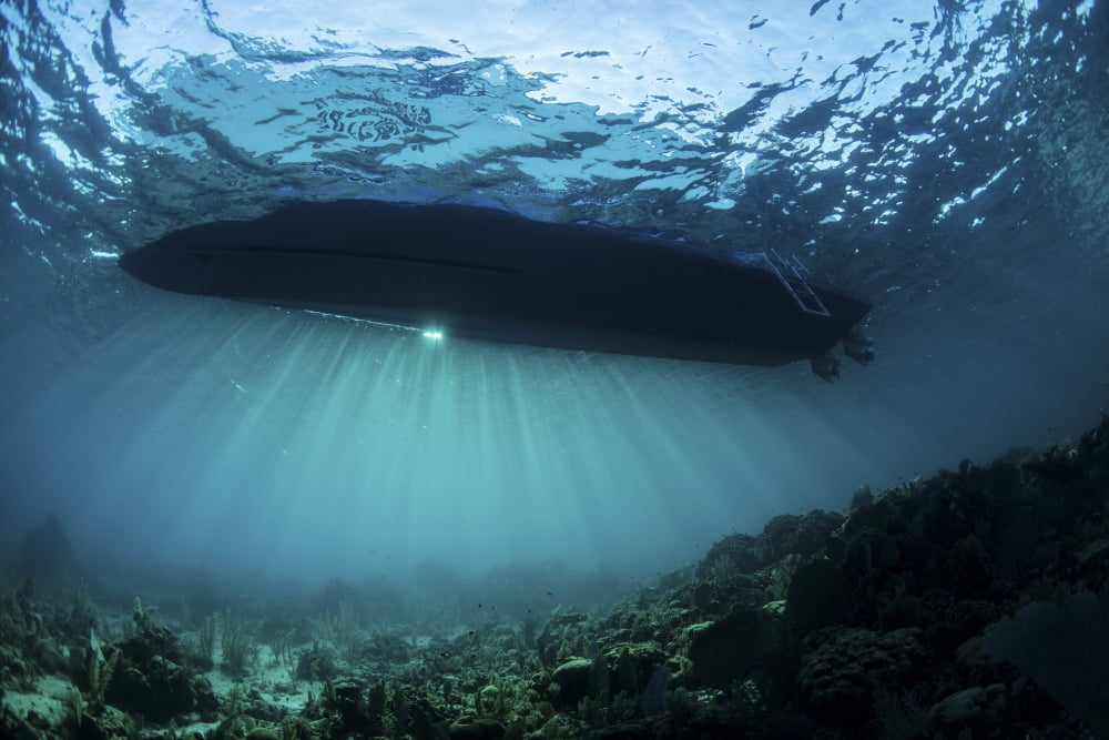 Sunlight silhouettes a boat floating in the Caribbean Sea Canvas Art - Ethan DanielsStocktrek Images (34 x 23)