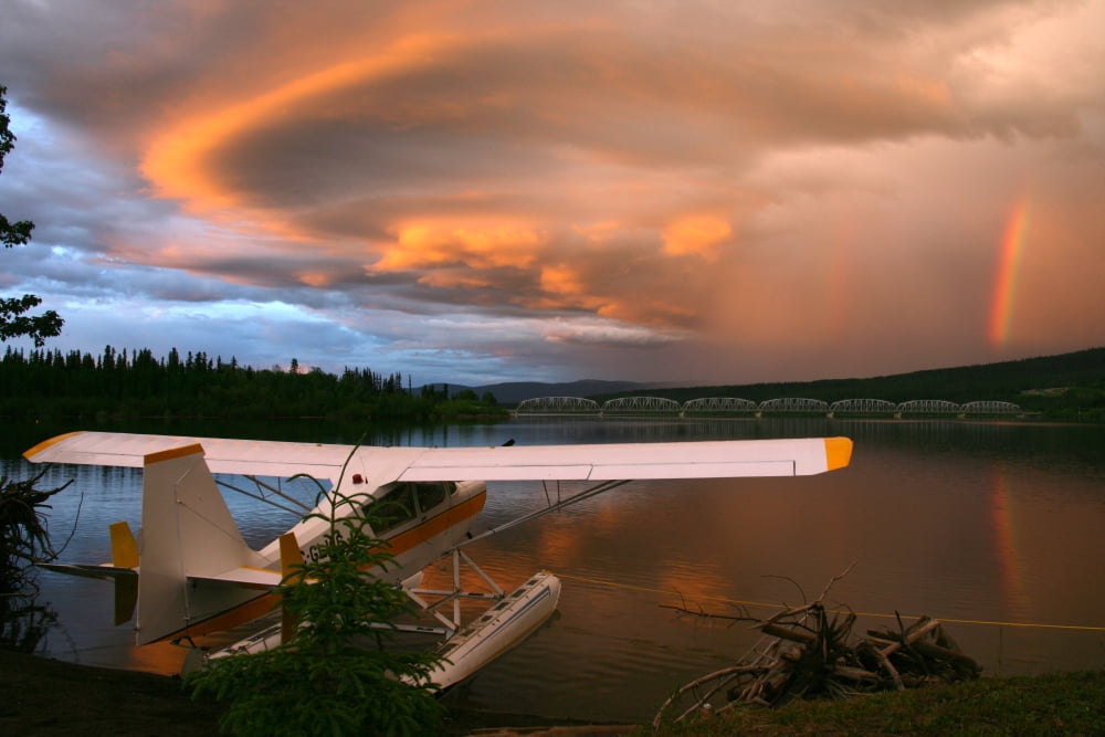 Sunlit Storm Clouds Over A Float Plane With Rainbow And Teslin Bridge In Background Teslin Lake Yukon Canvas Art - Robert Postma Design Pics (17 x 11)