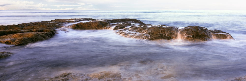 Sunrise highlights the interplay of surf and stone as waves come ashore at Las Rocas Beach Baja California Mexico Canvas Art - Panoramic Images (36 x 12)