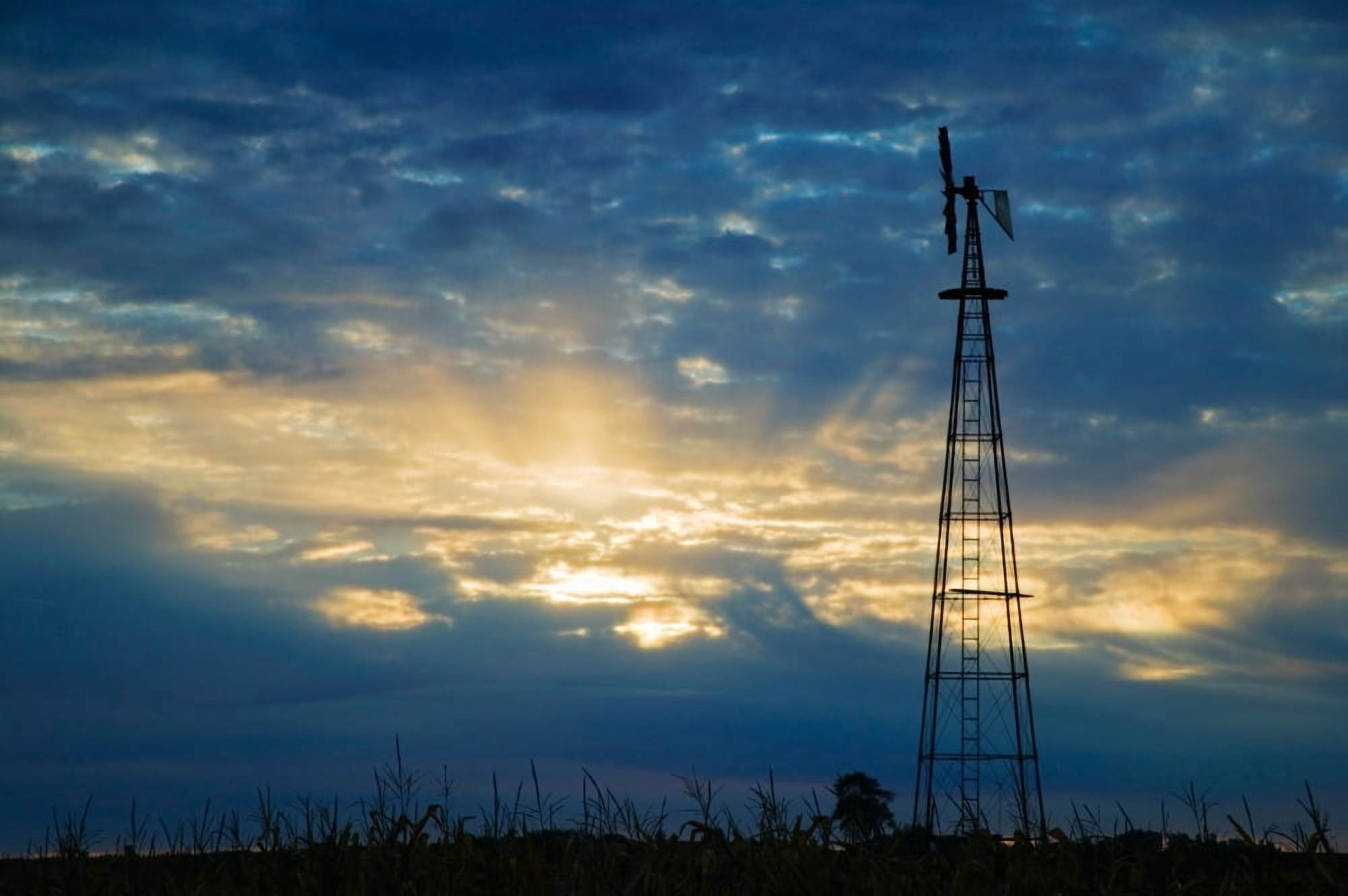 Sunset light through heavy clouds silhouetted windmill Iowa USA Canvas Art - Panoramic Images (27 x 9)