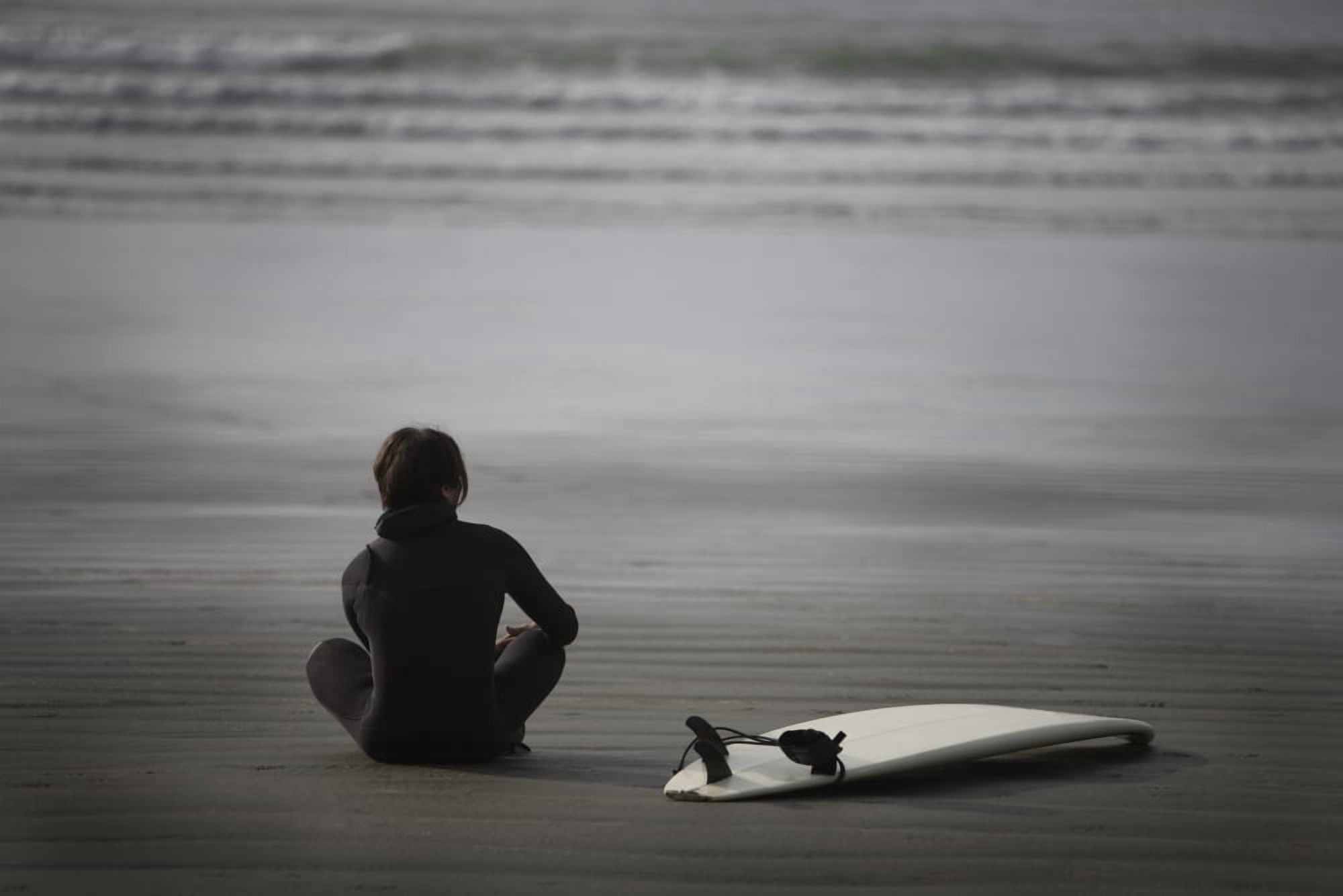 Surfer Sitting On Beach Cox Bay Near Tofino British Columbia Canada Canvas Art - Deddeda Design Pics (17 x 11)