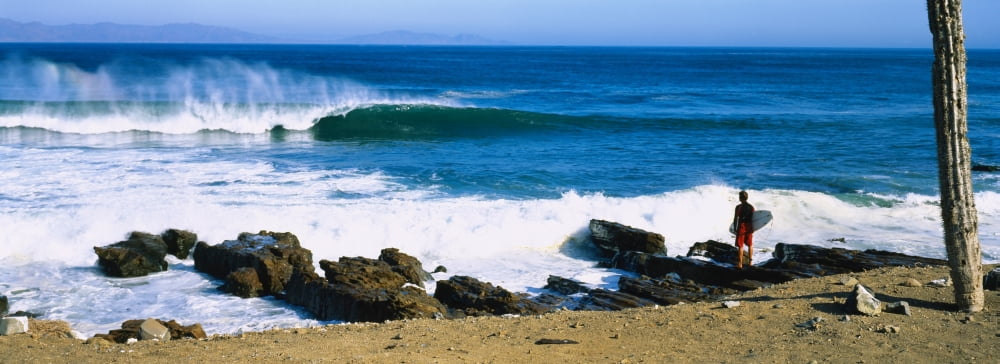 Surfer standing on the beach and looking at surf Isla Natividad Baja California Mexico Canvas Art - Panoramic Images (36 x 12)